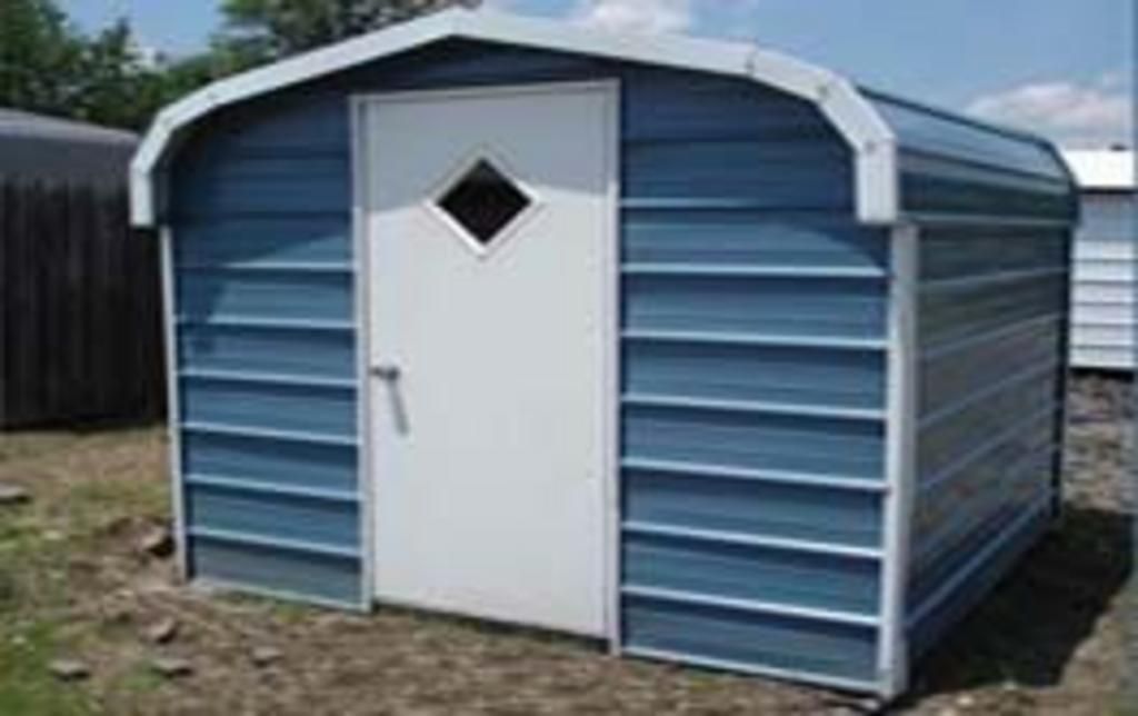 A blue and white shed with a white door and window.