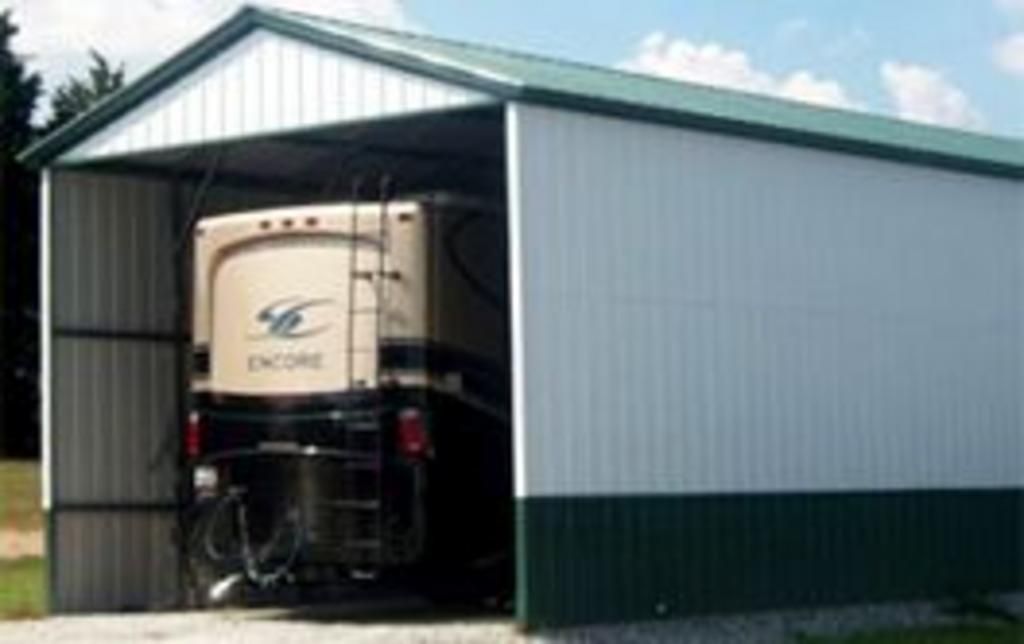 A rv is parked in a garage with the door open