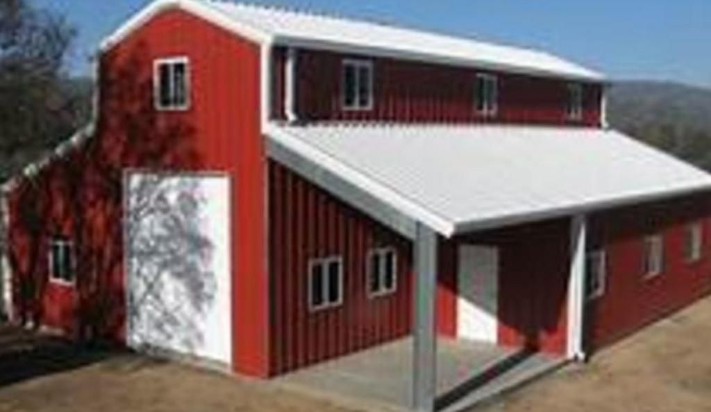 A red barn with a white roof and a porch.