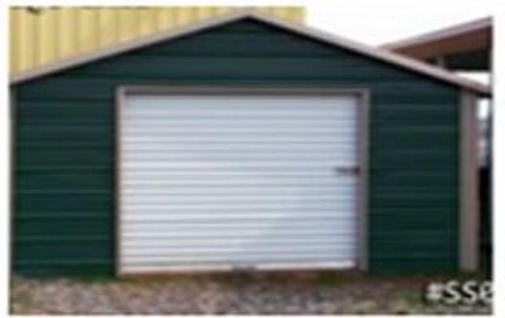 A green garage with a white garage door.