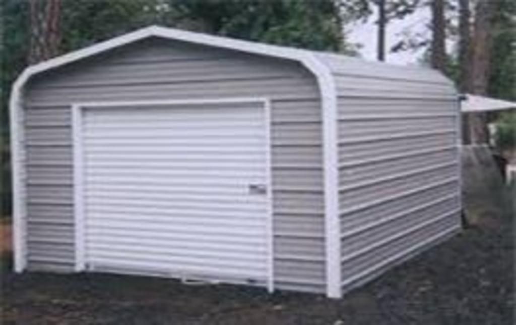 A metal garage with a white door is sitting on top of a dirt field.