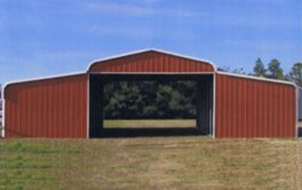 A red barn with the door open in a field.