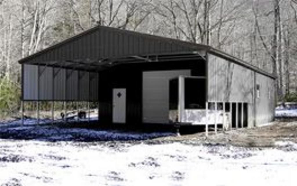 A black and white photo of a garage in the snow.