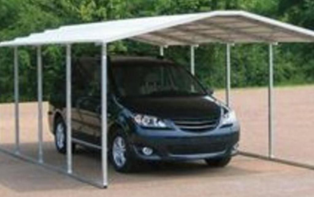 A car is parked under a carport in a parking lot.