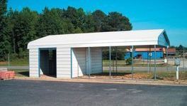 A white garage with a canopy attached to it