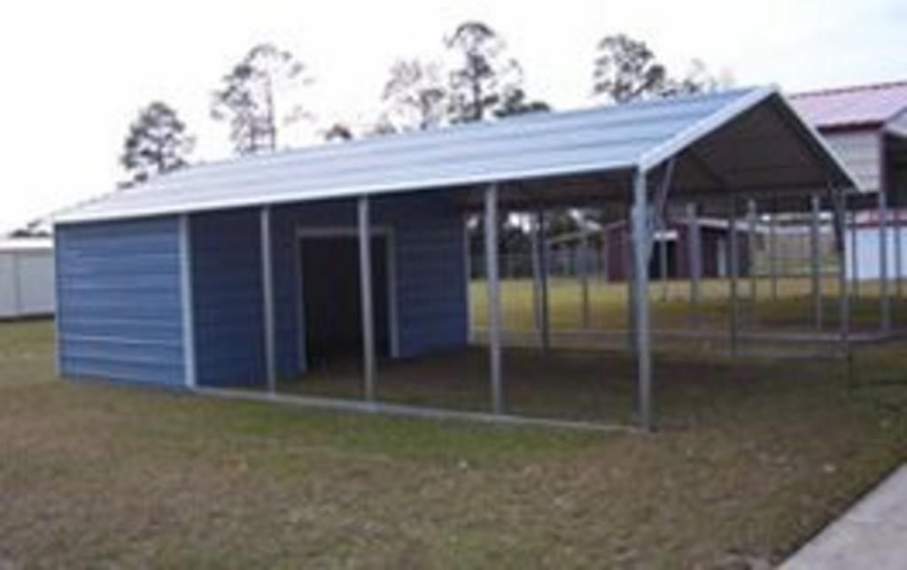 A blue shed with a metal roof is sitting on top of a lush green field.