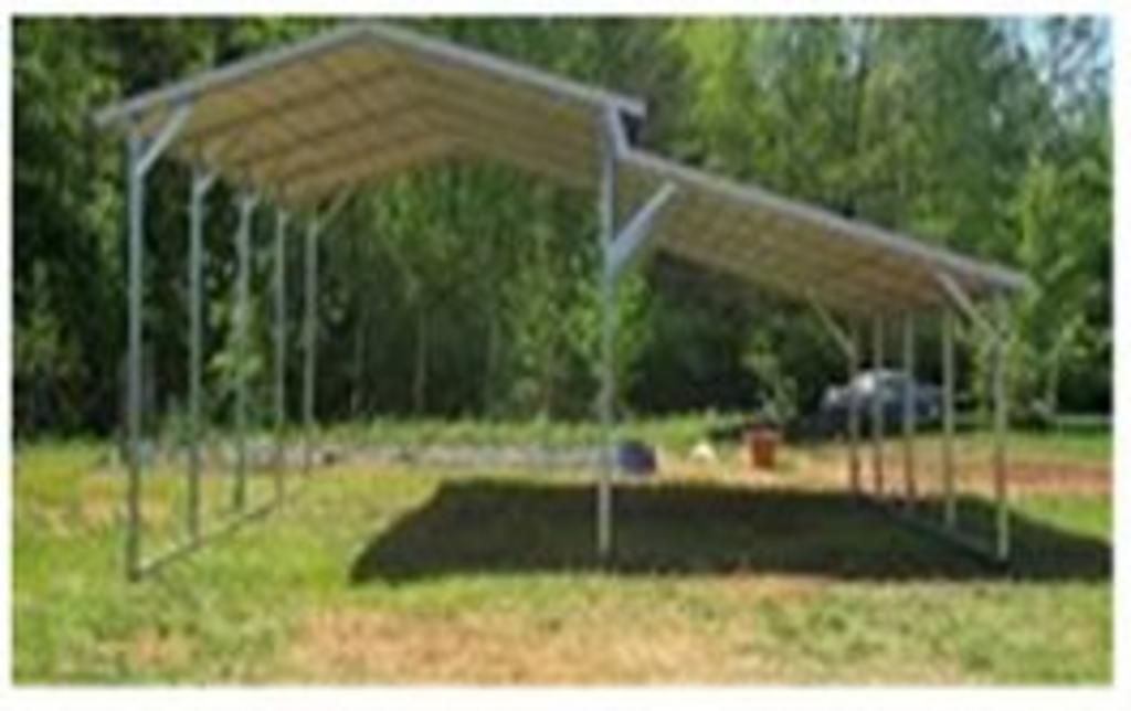 A carport is sitting in the middle of a grassy field.