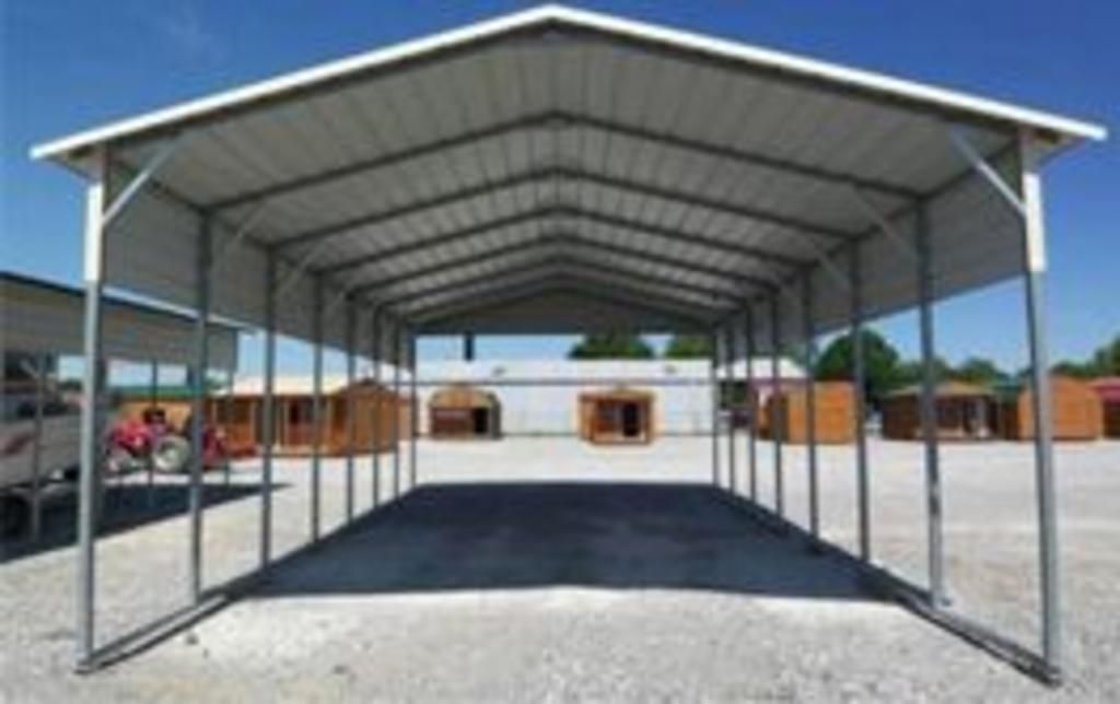 A carport with a white roof is in a parking lot.