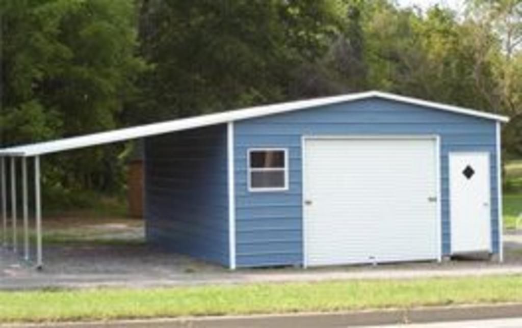 A blue garage with a white roof and a carport attached to it.