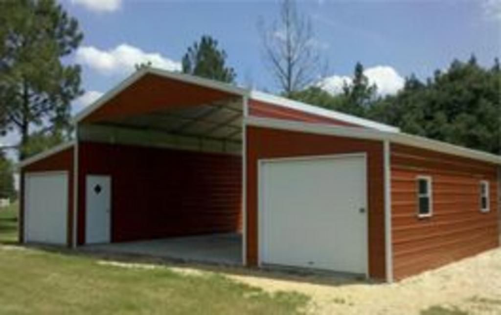 A red garage with a white door is sitting in the middle of a grassy field.