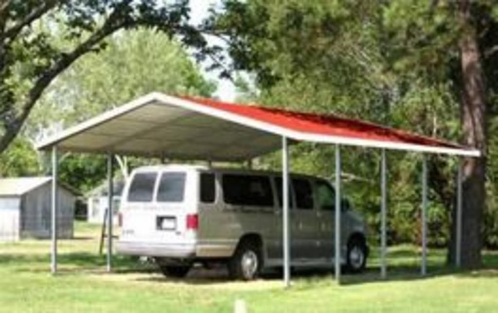 A van is parked under a carport with a red roof.