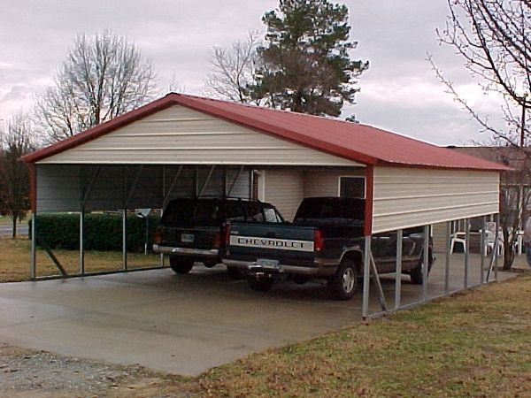 A chevrolet truck is parked under a carport