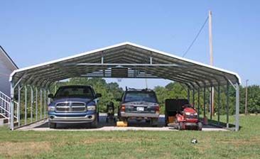 A couple of cars are parked under a carport.