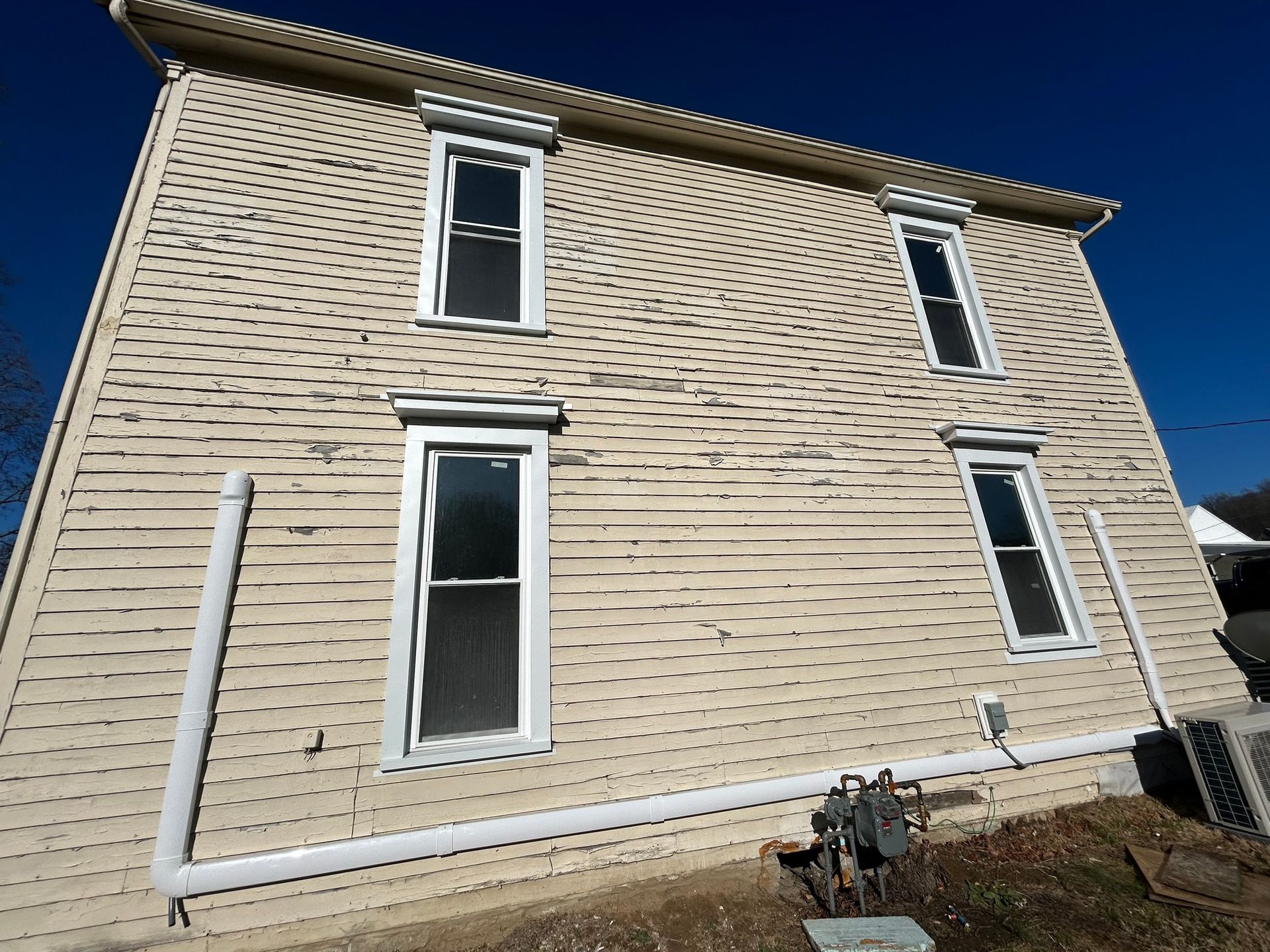 A large white house with a blue sky in the background