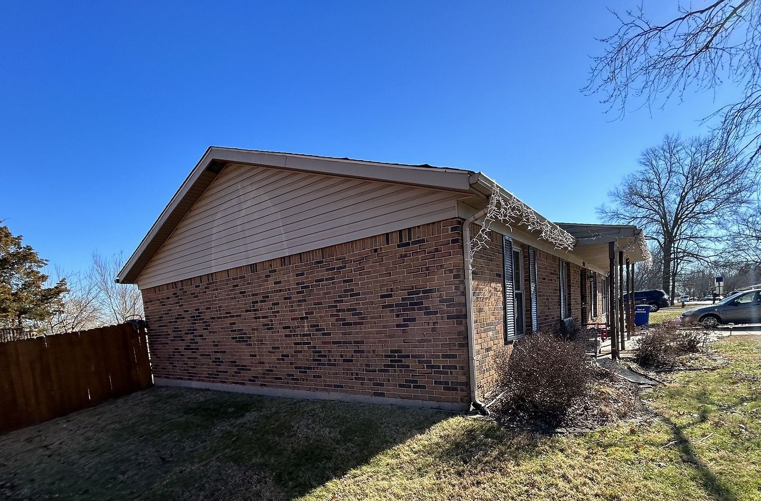 A small brick house with a car parked in front of it.