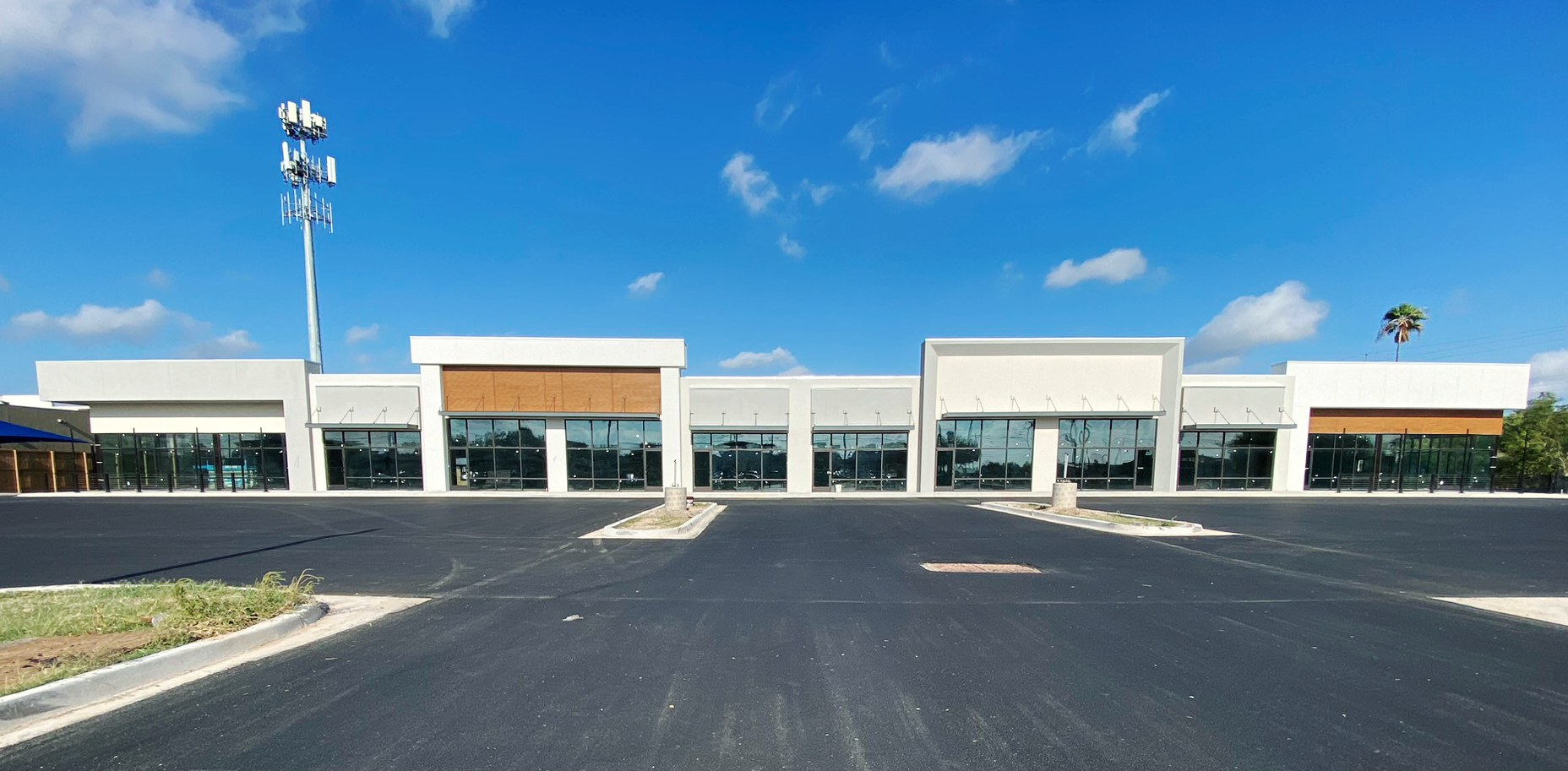 A large building with a lot of windows and a parking lot in front of it.