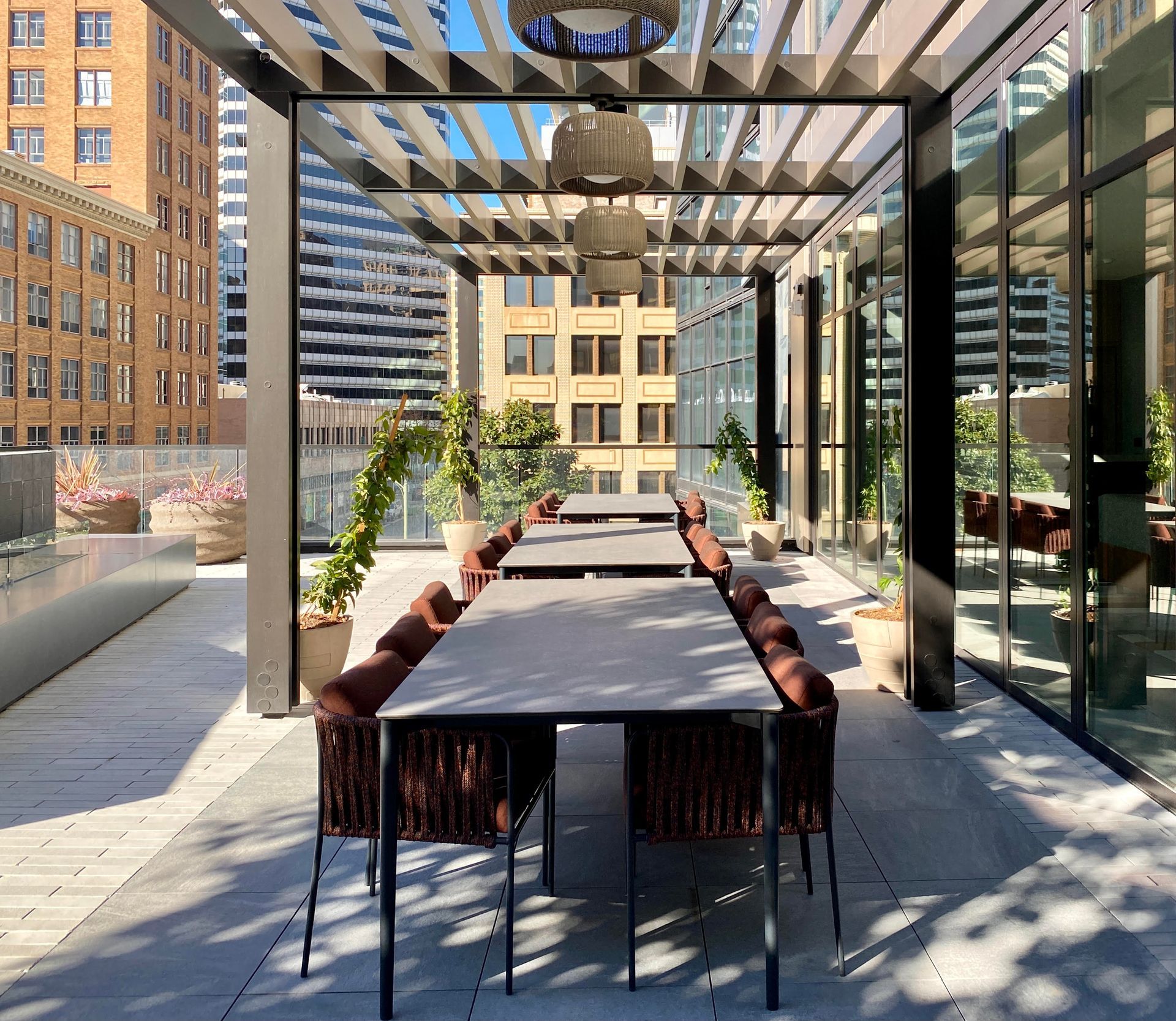 A patio with a long table and chairs under a pergola