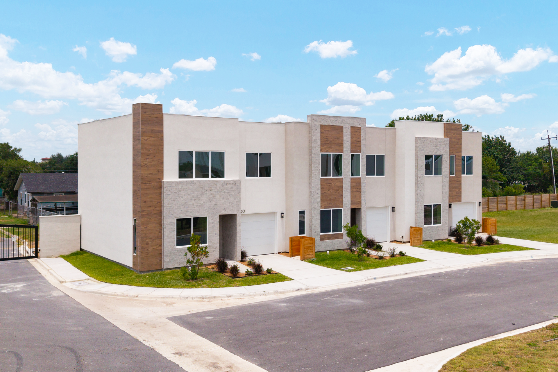 An artist 's impression of a row of houses with trees in front of them.