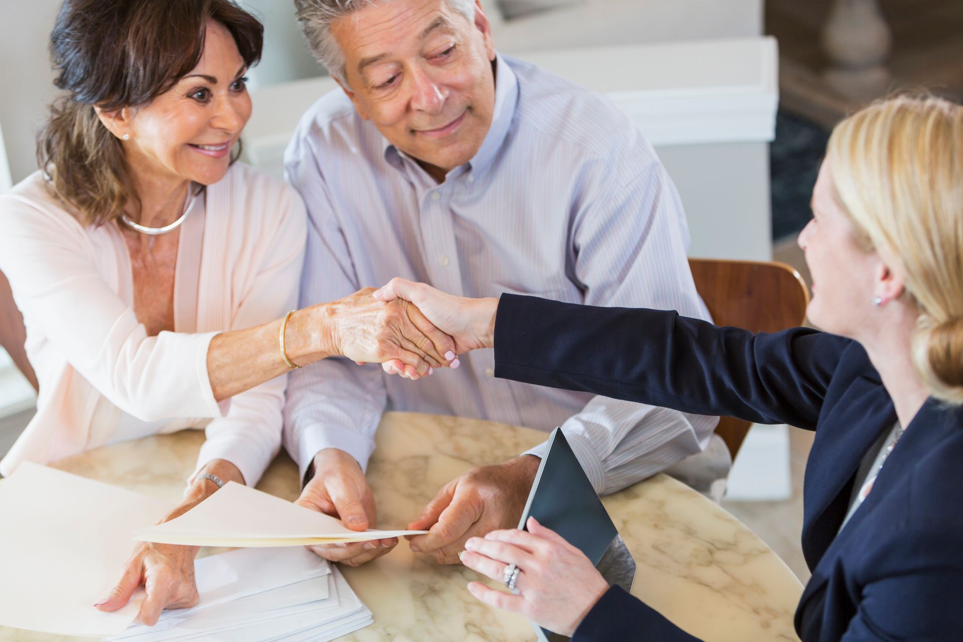 Senior couple is shaking hands with a real estate attorney from The Peet Law Group in South Burlingt