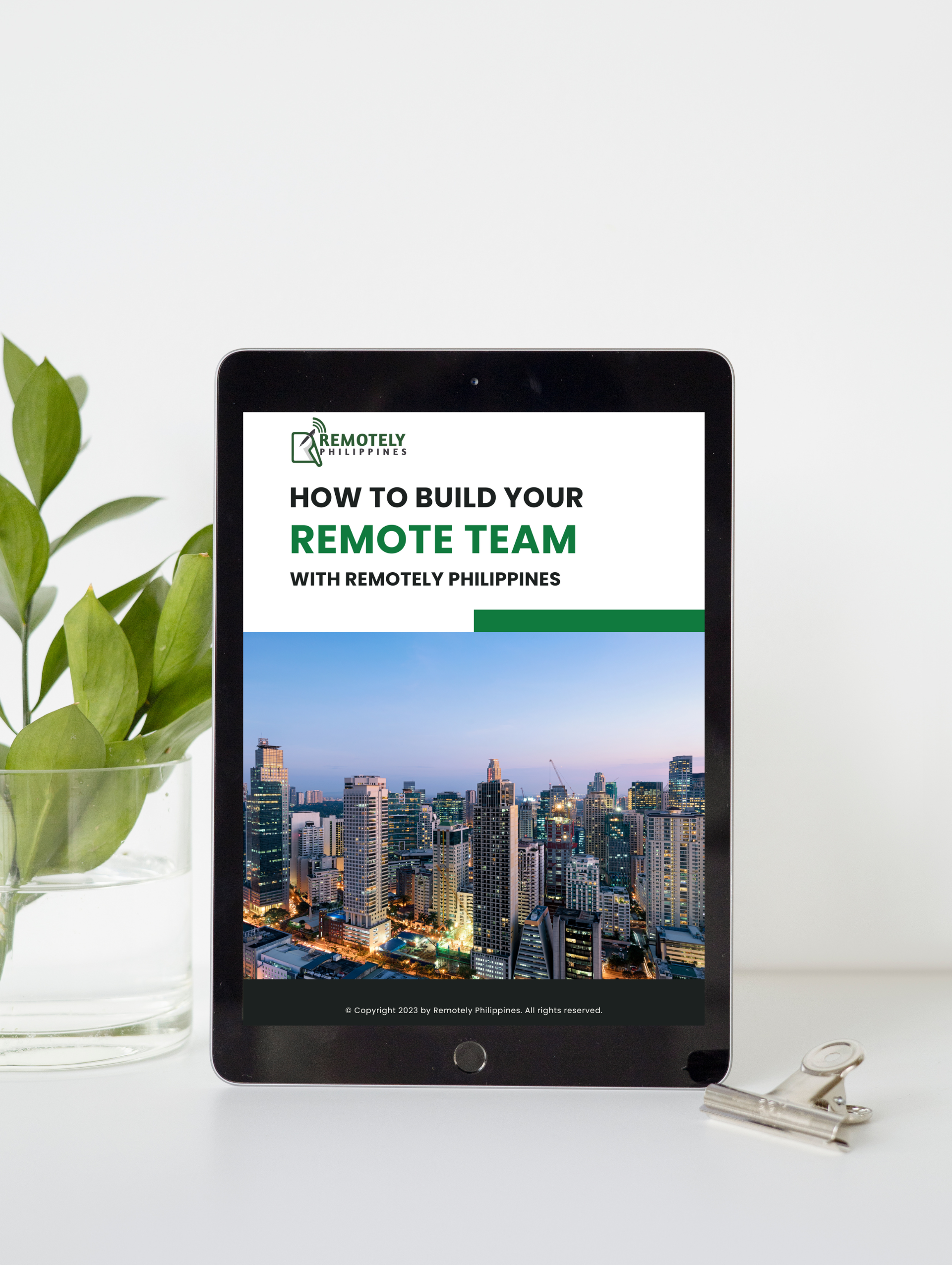 A tablet is sitting on a table next to a plant.