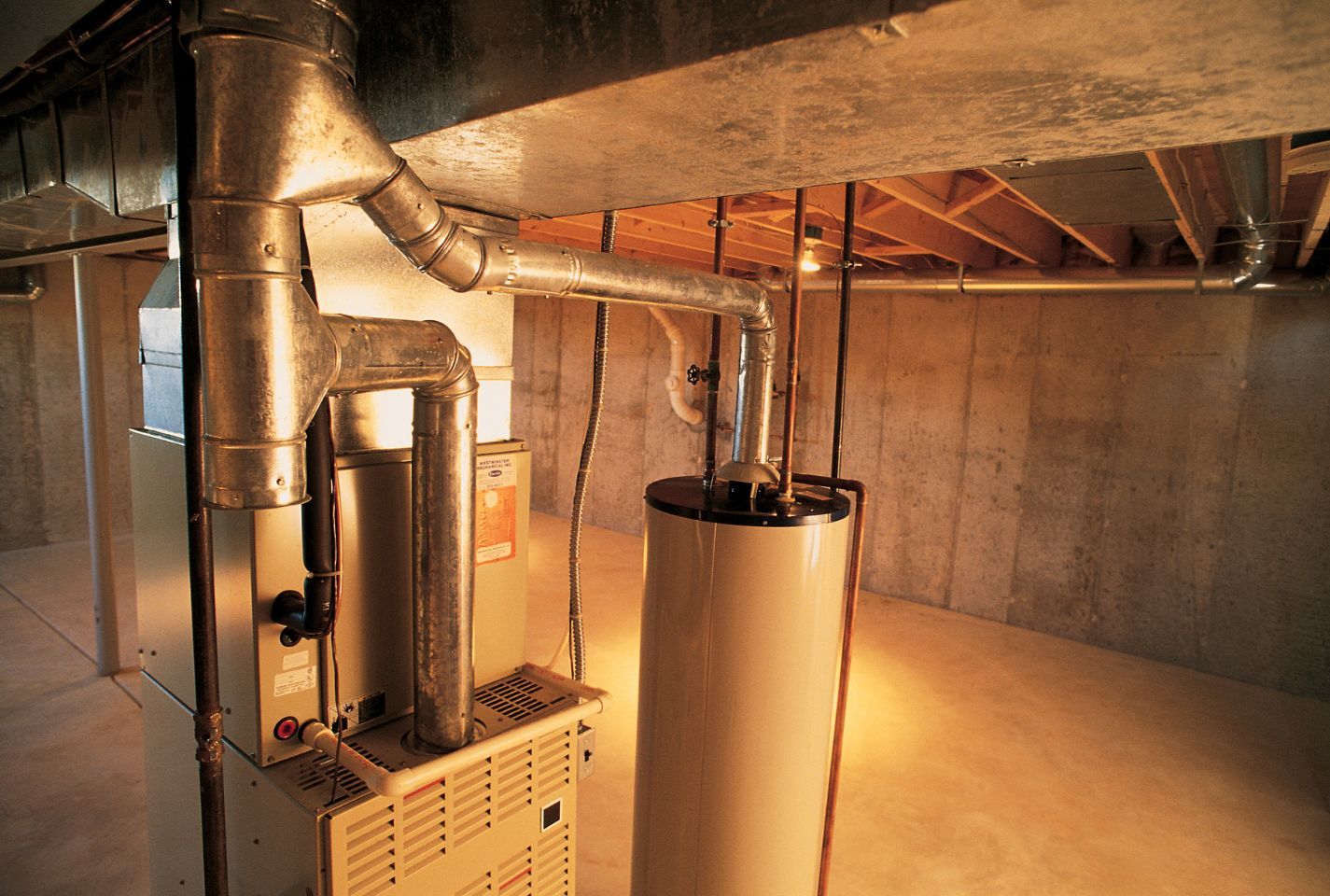 A basement with a furnace and a water heater.