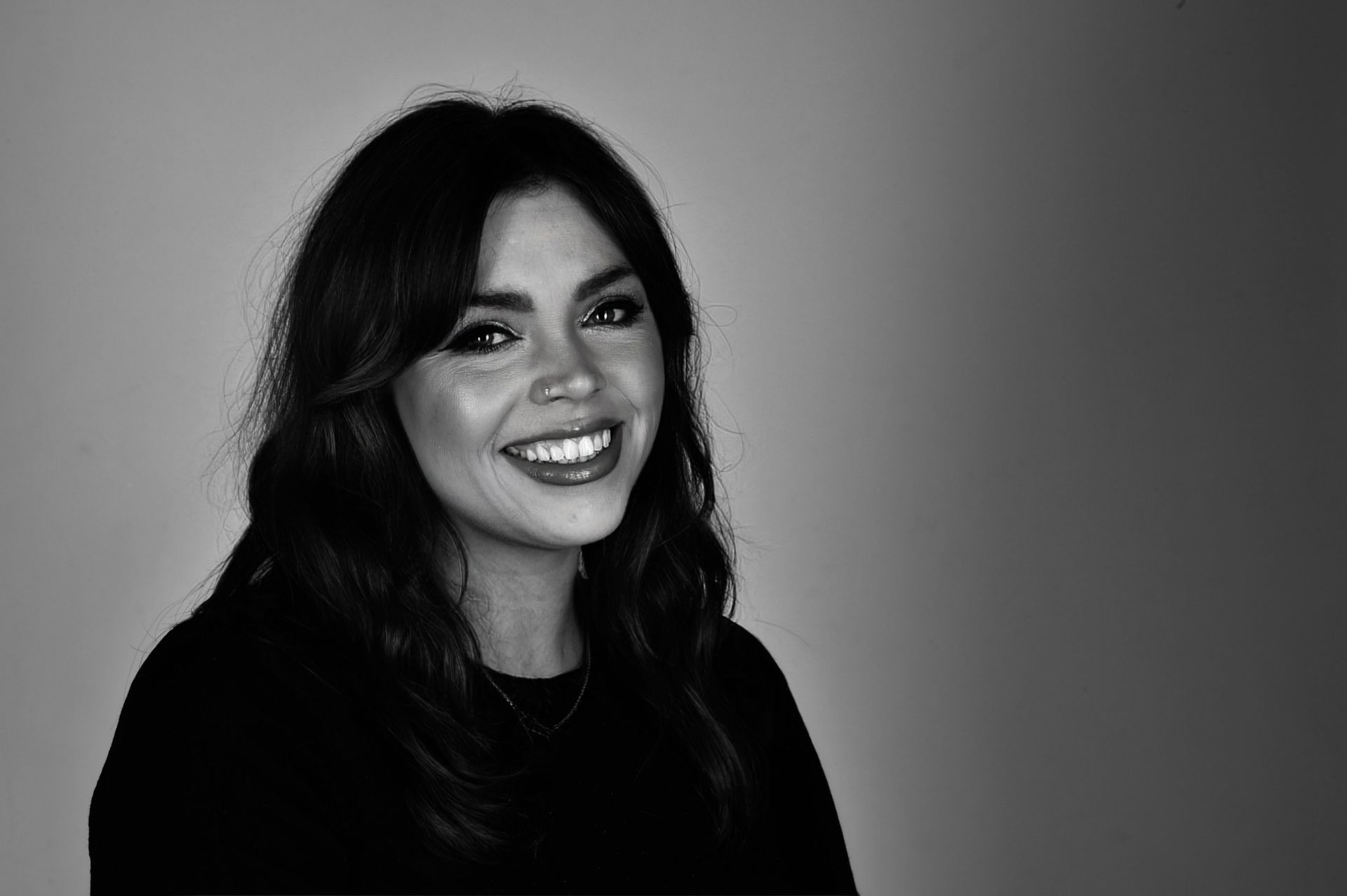 A black and white photo of a woman smiling.