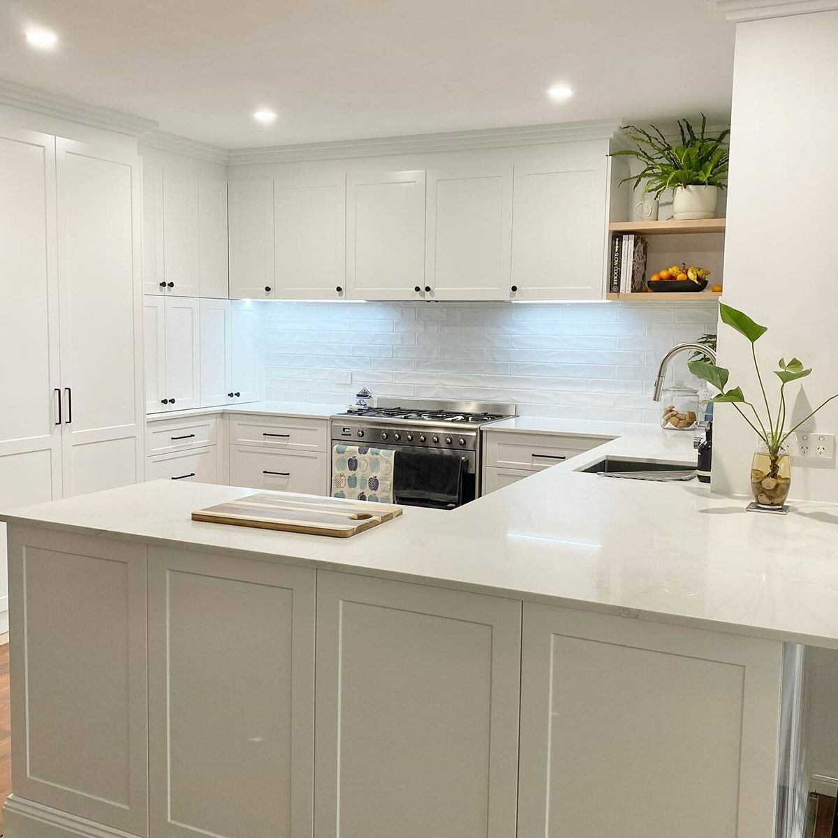 A Kitchen With White Cabinets , A Stove , A Sink , And A Large Island — Kreuzer Cabinets In East Wagga Wagga, NSW