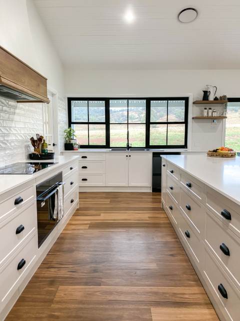 A Kitchen With White Cabinets, Wooden Floors, and Black Handles — Kreuzer Cabinets In East Wagga Wagga, NSW