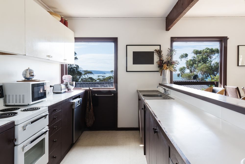 A Kitchen With Brown Cabinets and White Counter Tops — Kreuzer Cabinets In Albury, NSW