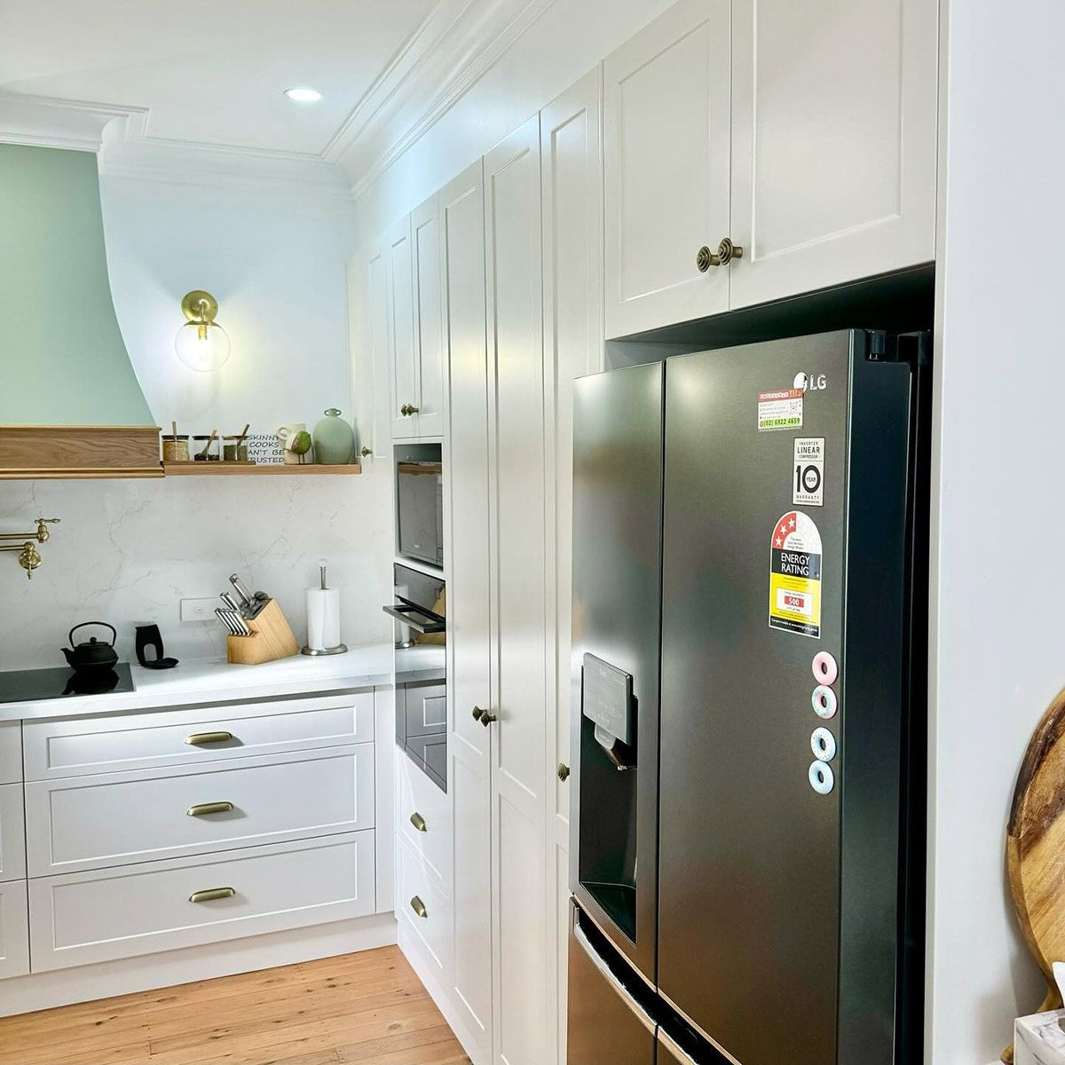 A Kitchen With White Cabinets And A Black Refrigerator — Kreuzer Cabinets In East Wagga Wagga, NSW