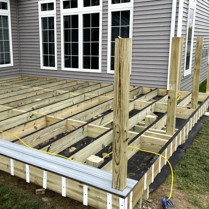 A wooden deck is being built in front of a house.