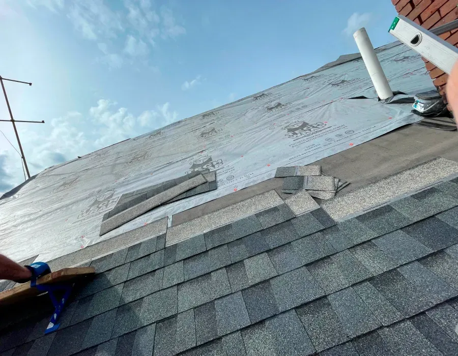 A person is working on a roof with a saw.