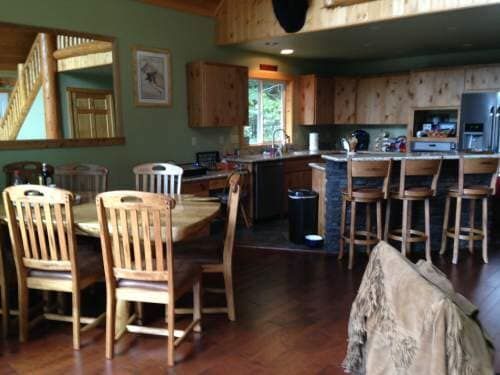 Kitchen and dining area with wooden furniture and green walls.