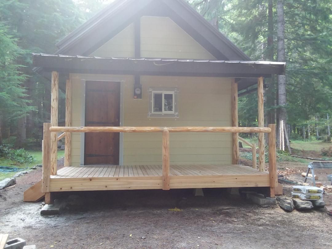 Gray two-story house with a green lawn, white trim, and a two-car garage.