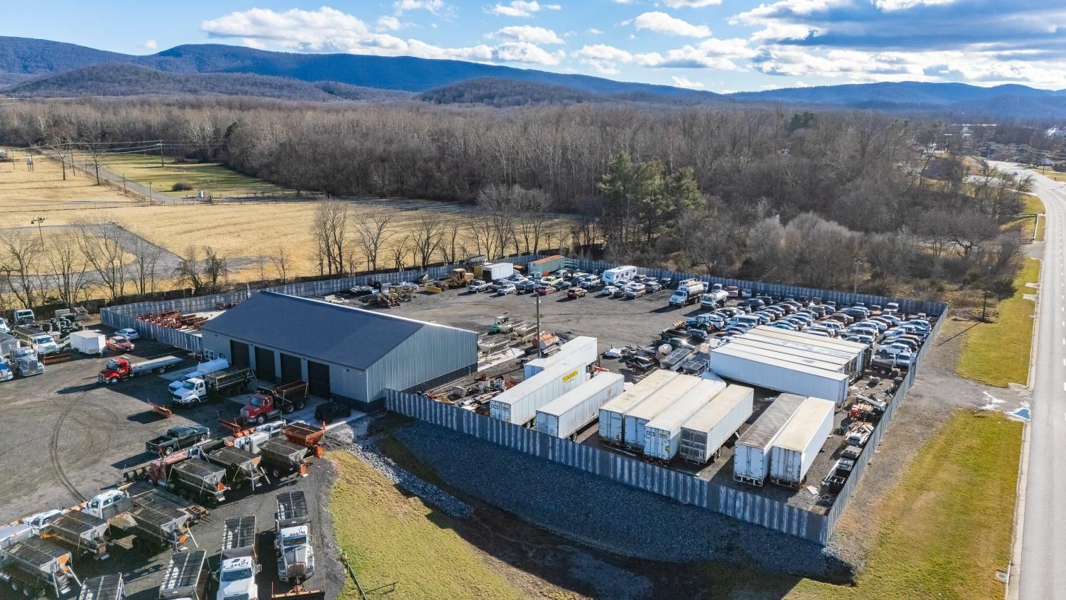 An aerial view of a warehouse filled with lots of cars and trucks.