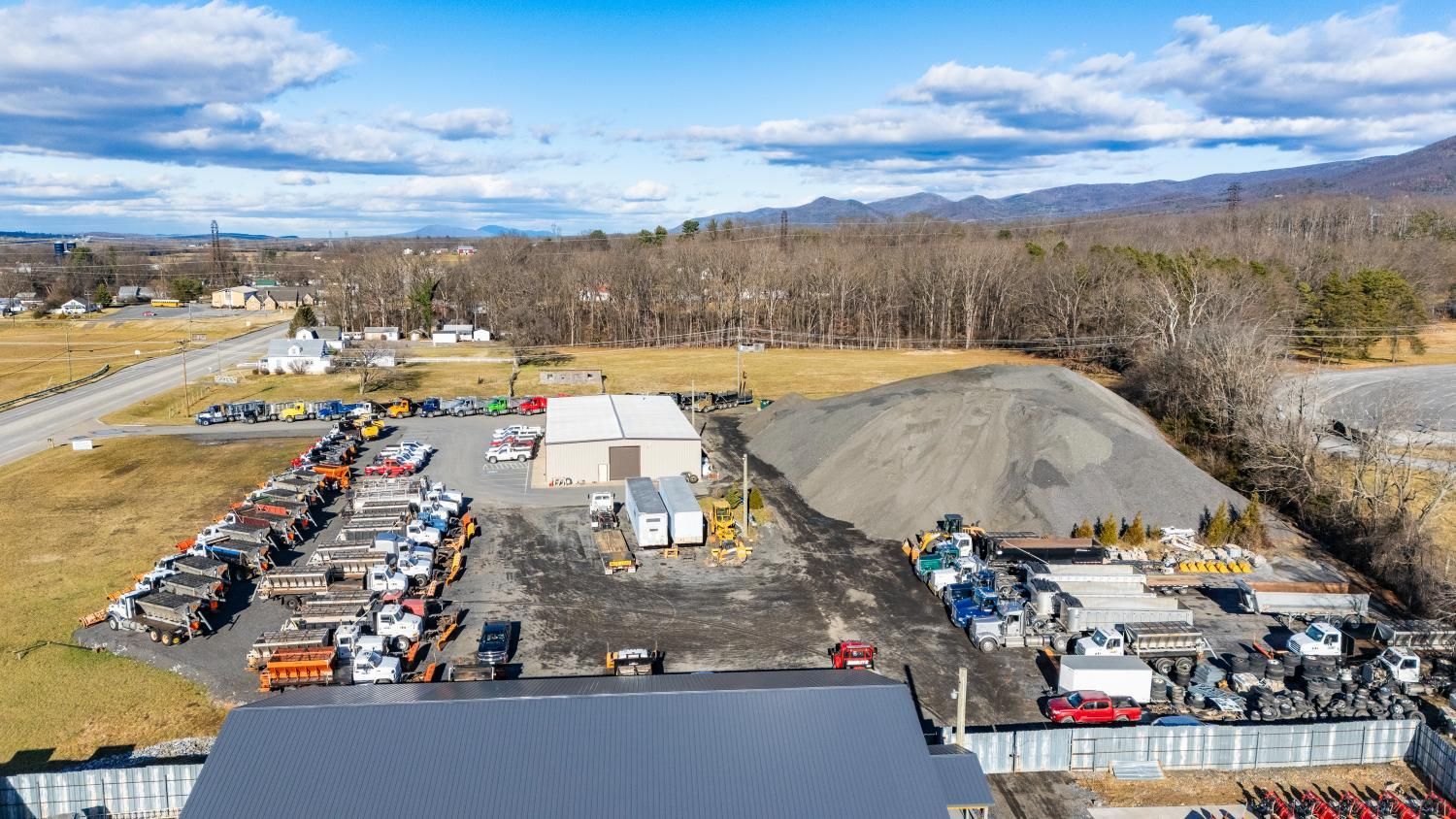 An aerial view of a large warehouse filled with lots of cars and trucks.