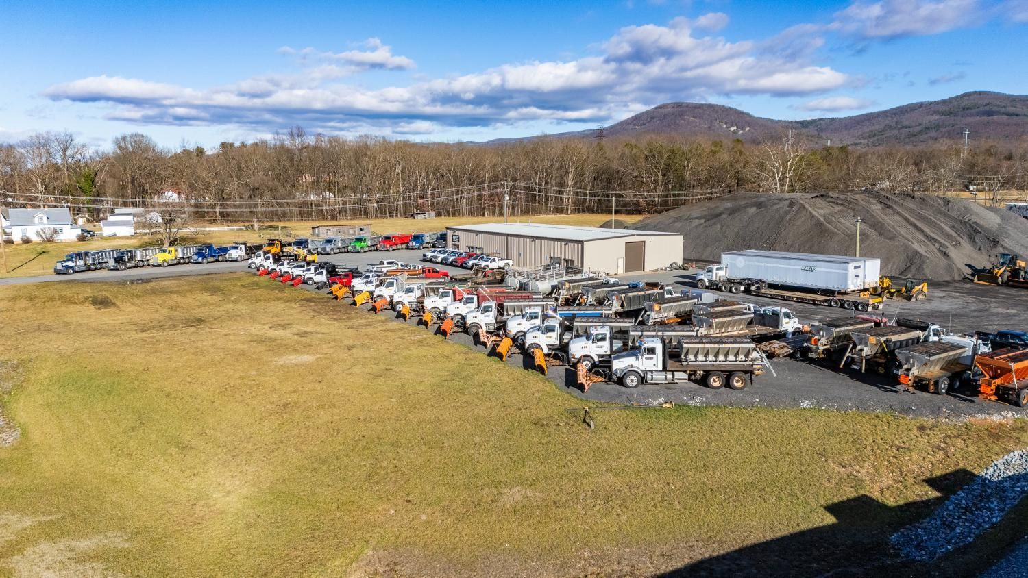An aerial view of a large parking lot filled with trucks and tractors.