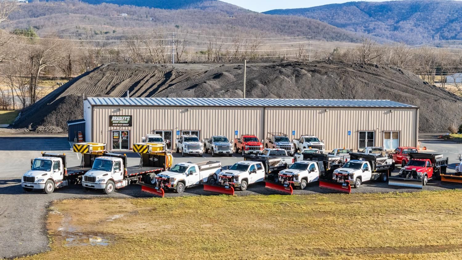 A large building with a lot of trucks parked in front of it.