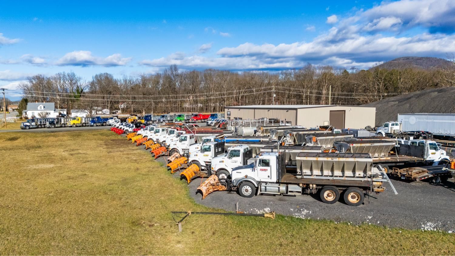 A lot of trucks are parked in a field.