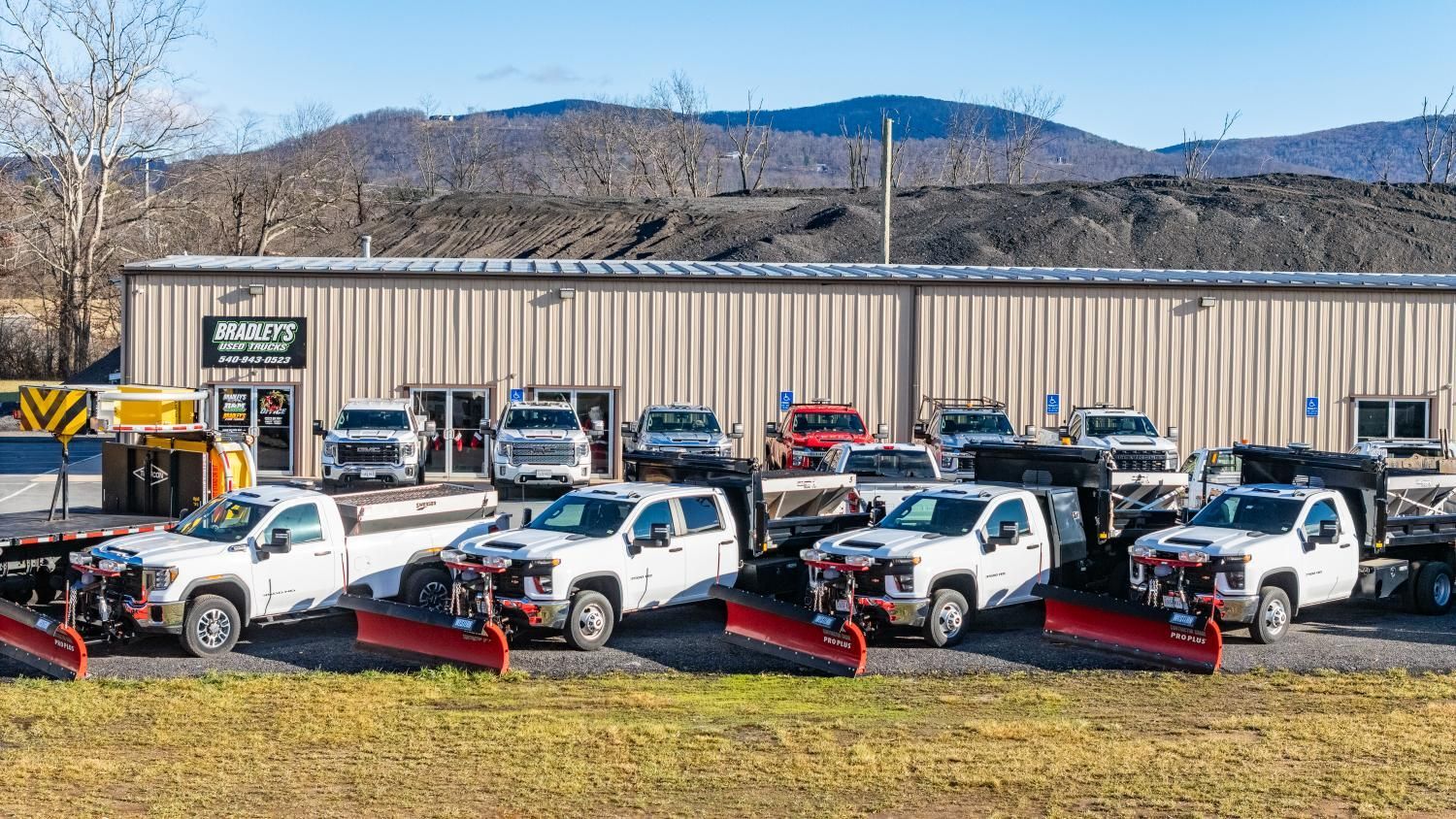 A row of snow plows parked in front of a building.
