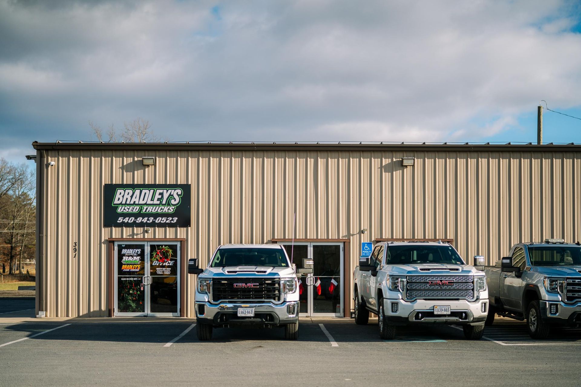 A row of trucks are parked in front of a building.
