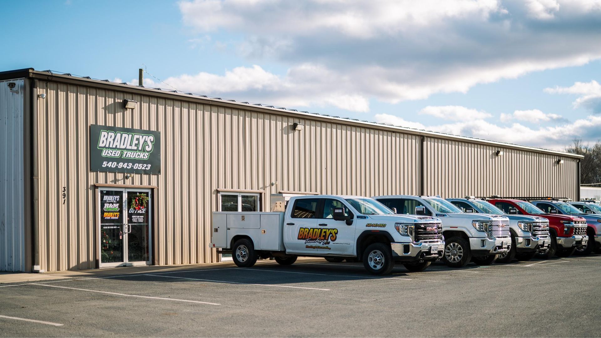 A row of trucks are parked in front of a building.