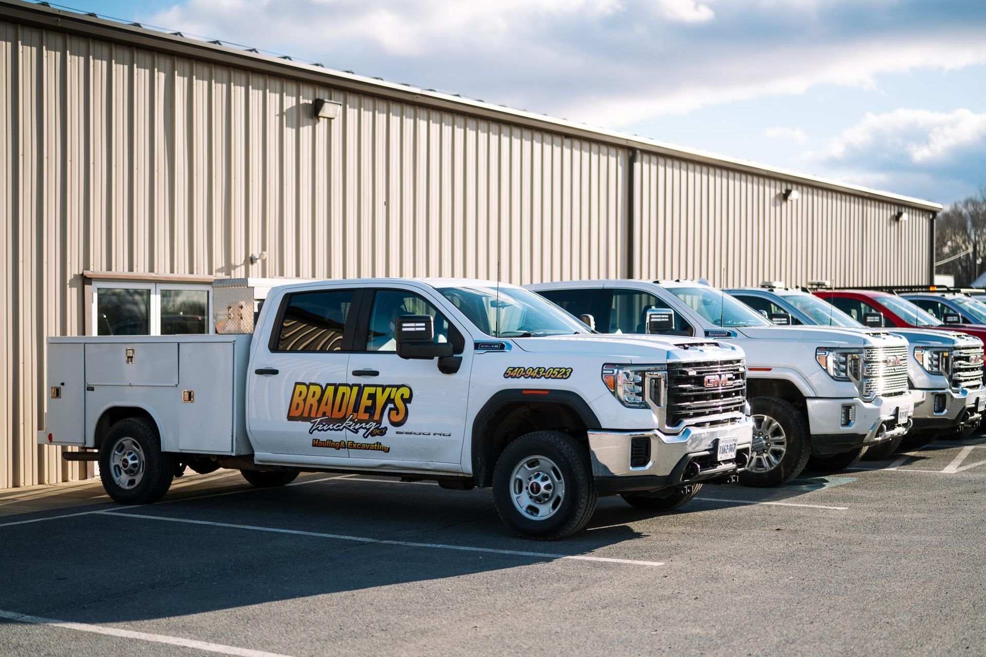 A row of white trucks parked in front of a building.