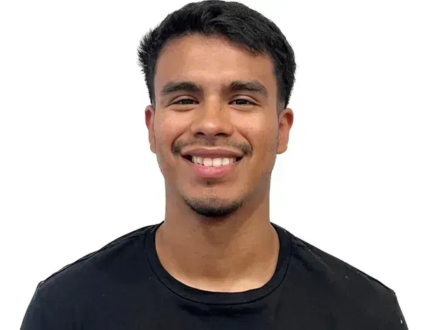 Smiling person in a black shirt, against a white background.