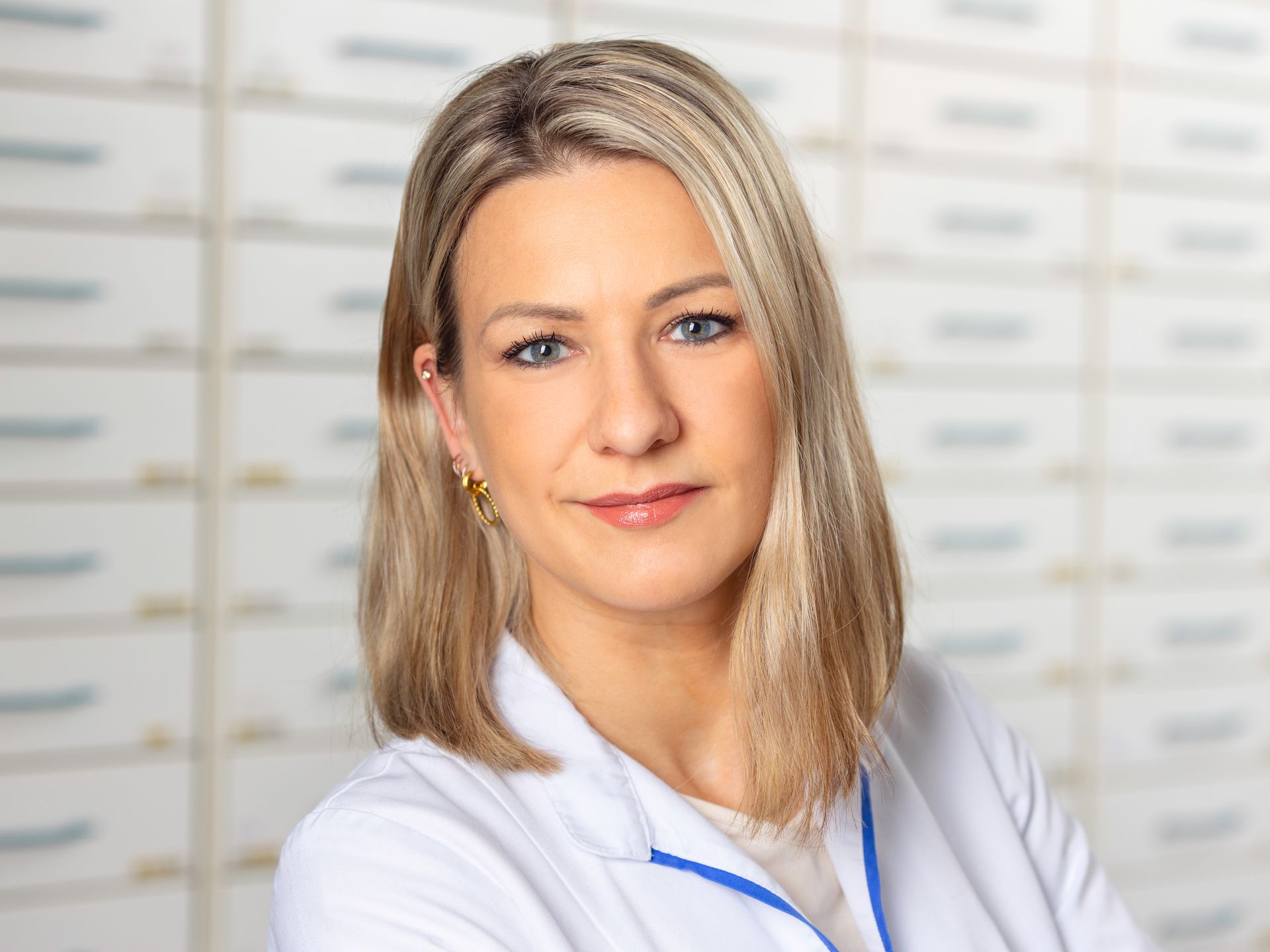 Eine Frau in einem weißen Laborkittel posiert für ein Foto.