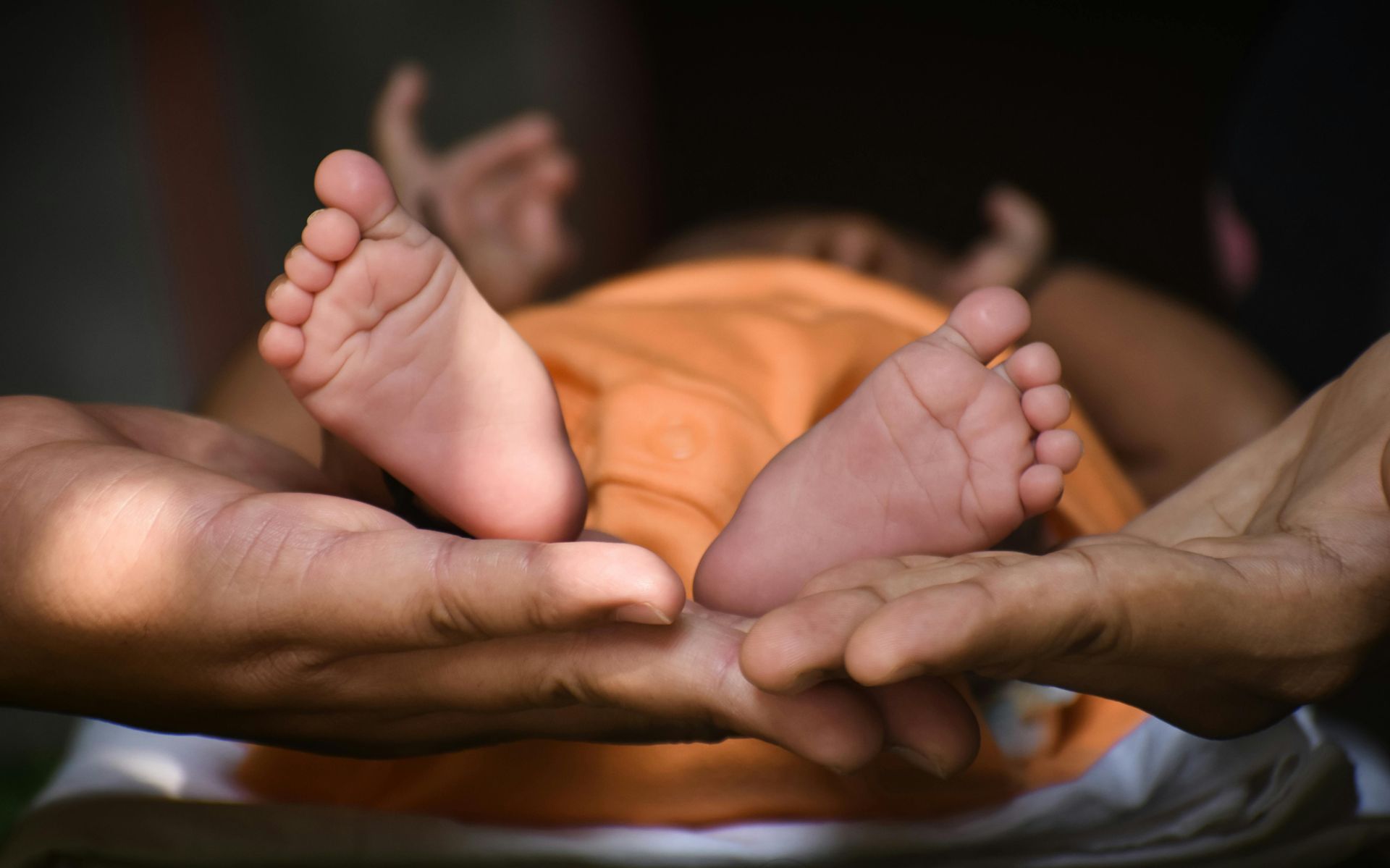 A person is holding a baby 's feet in their hands.