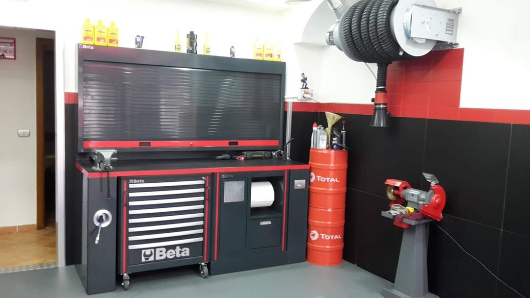 A garage with a lot of tools and a large tire on the wall