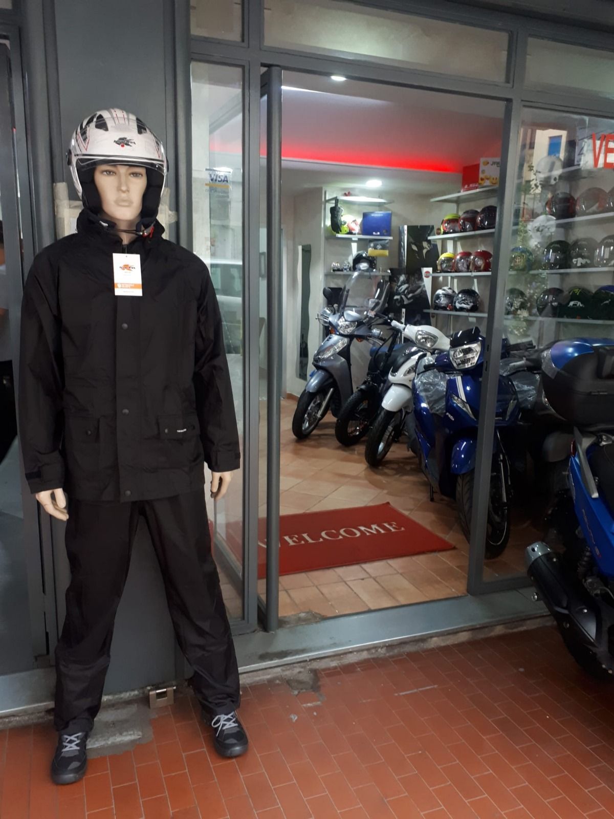 A mannequin wearing a helmet is standing in front of a store.