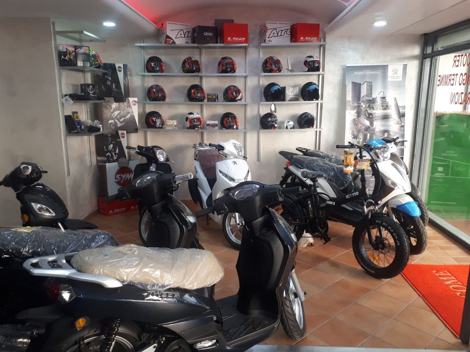 A showroom filled with motorcycles and helmets.