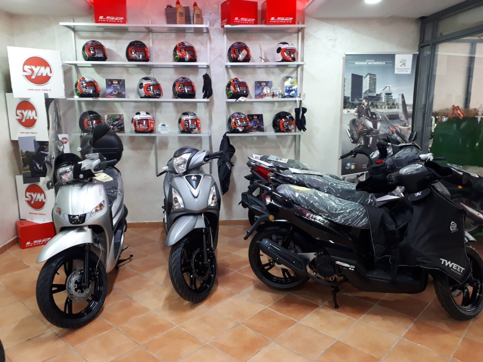 Three scooters are parked in a showroom.